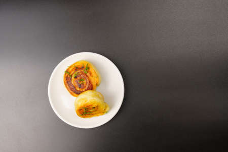 delicious homemade fried pies with potatoes on a white plate. Black background. copy space.