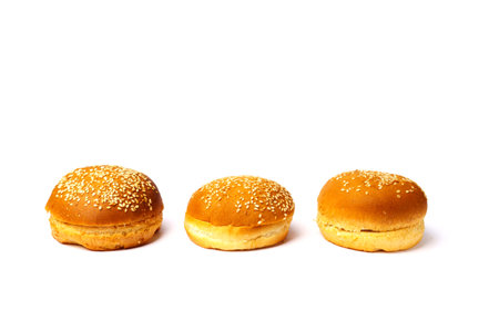 Three buns with sesame seeds isolated on a white background.の写真素材