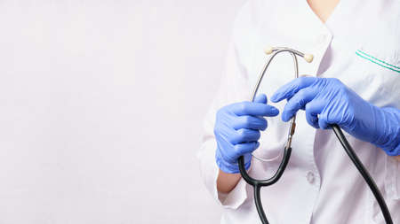 doctor holding stethoscope on white wall background with copy spaceの写真素材