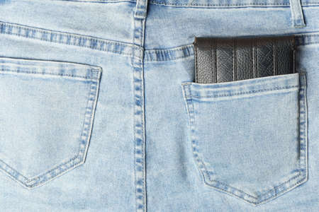 Black old leather wallet in the back pocket of jeans. close-up