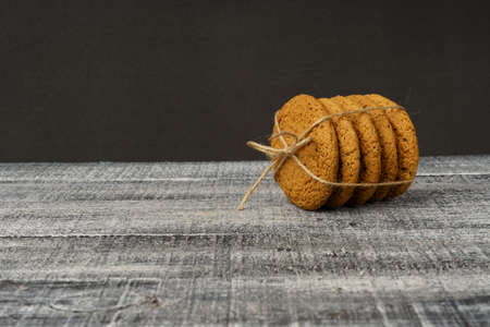 oatmeal cookies tied with twine lies on a black background with copy space.