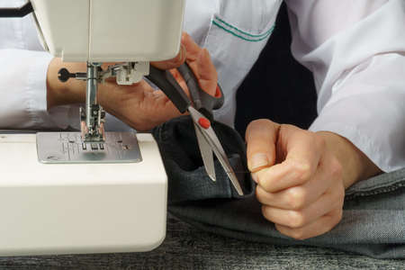 the seamstress cuts the thread. the process of cutting and sewing clothes. close-up