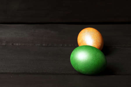 two colored Easter eggs on a dark wooden background. banner with place for textの写真素材