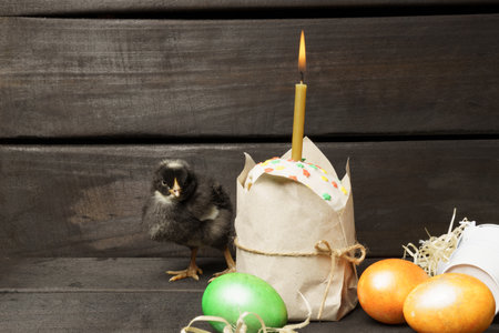 little chicks Easter cake and colored eggs on a dark wooden background. Easter card, banner