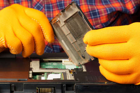 The man is taking apart the laptop. Laptop repair and cleaning. close-upの写真素材