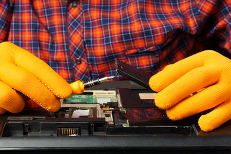 The man is taking apart the laptop. Laptop repair and cleaning. close-upの写真素材