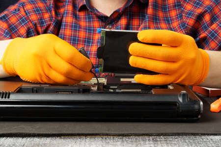 The man is taking apart the laptop. Laptop repair and cleaning. close-upの写真素材