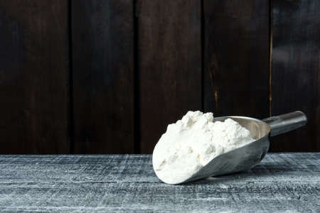 iron scoop of wheat flour on a dark background with copy space. banner mockup for recipe bookの写真素材