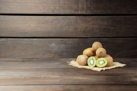 kiwi on a wooden background. a bunch of ripe kiwi fruit on a napkin on a wooden background with copy spaceの写真素材
