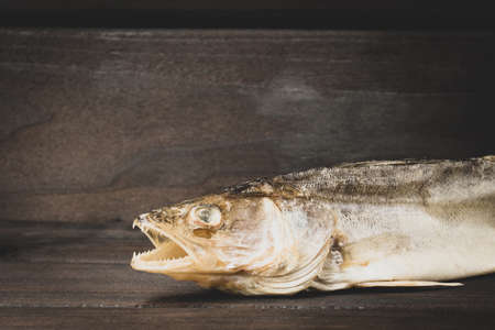 pike perch, dried salted fish, on dark wood background with copy spaceの写真素材