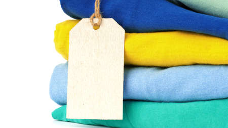 stack of colored clothes with blank tag isolated on white background. concept of sales, discounts