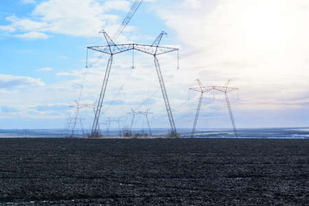 power pylons and high voltage lines in an agricultural landscapeの写真素材
