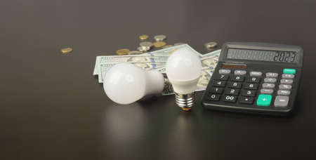 energy saving concept. calculator with two LED lamps on a black background, with free space for textの写真素材