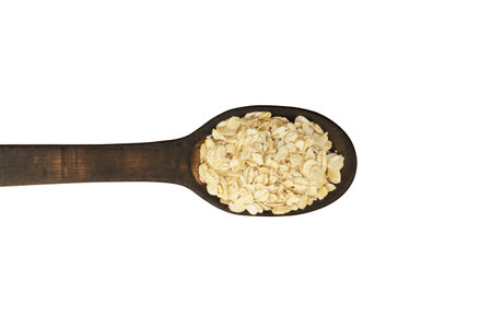 raw oatmeal in wooden spoon isolated on white background, top view