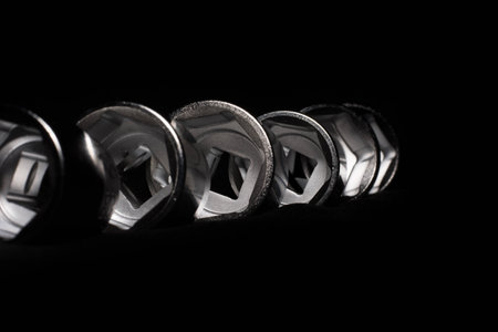 Set of chrome wrenches on black background. Close up.