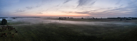 Aerial view of fields with fog at amazing sunset. Summer nature landscape. Panorama.