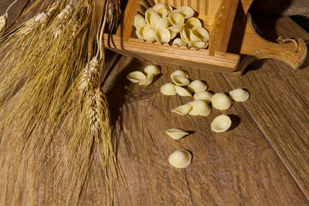 Italian healthy organic food still life pasta orecchiette and ears of wheatの写真素材