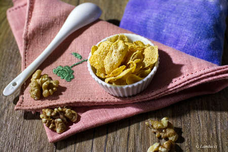 healthy breakfast cornflakes and walnut on pink napkin