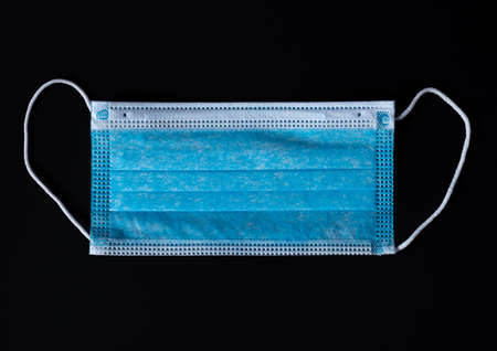 Single new Medical face mask in a black backgroundの写真素材