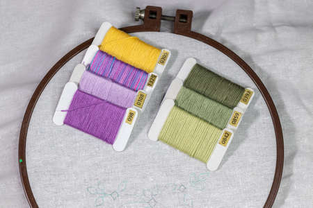 Wooden Embroidery hoop with a clean white piece of linen cloth and a simple design with a bunch of...