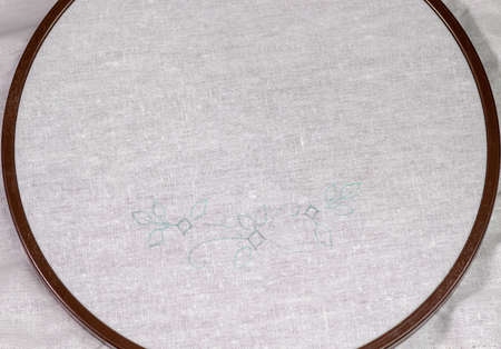 Wooden Embroidery hoop with a clean white piece of linen cloth and a simple design.の写真素材