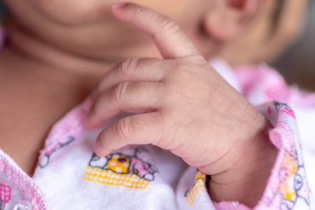 adorable cute baby girls hand and fingers close up macro photography, her veins also visible as...