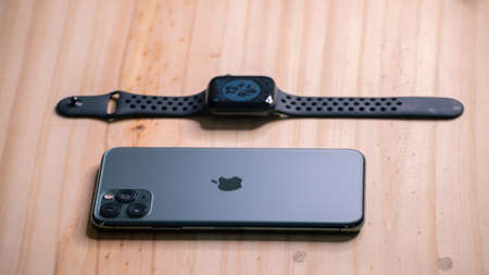 Galle, Sri Lanka - 02 19 2021: Apple iPhone 11 pro max and apple watch series 6 lay flat on a wooden table, luxury and lifestyle concept.のeditorial素材