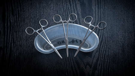 Hemostatic Forceps scissors lay flat on top of plastic equipment holder on a wooden table top,...