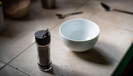 Instant coffee powder in a small transparent glass bottle and white bowl to whisk into foam, Dalgona...