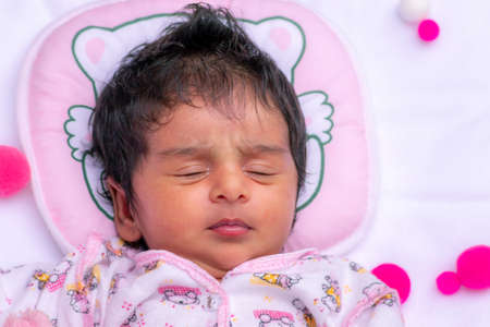 Cute newborn baby girls one-month birthday celebration photo session, Napping and dreaming time for the adorable infant. close up overhead view photograph of child portraiture.のeditorial素材