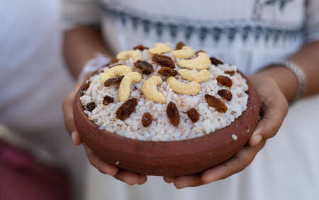 Kiripidu offering at Jaya Sri Maha Bodhi, Anuradhapura. White dresses girl holding bowl of milk rice...
