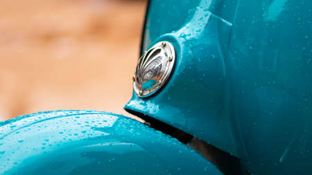 Vespa Scooter front close up view, parked in a muddy road in a rainy day. Sky blue vintage classic motor bike.のeditorial素材