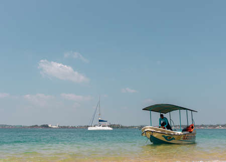 Galle, Sri Lanka - 01 29 2020: Group of friends swimming in the clear waters in jungle beach, hands in the air,のeditorial素材