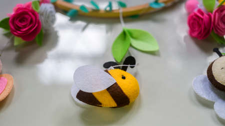 Cute prop for baby cot mobile closes up. Felt plush bees with flowers design.の写真素材