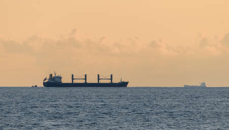 Nautical vessels in the horizon, evening seascape shot in Galle fort. Large cargo ships and small fishing boats.の写真素材