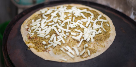 Toasting cheese quesadillas on a hot griddle. Cheese and spicy paste as a topping for the tortilla.の写真素材