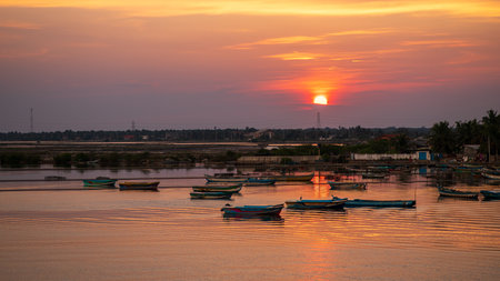 Stunning sunset illuminates the harbor in Mannar, Sri Lanka. Colorful fishing boats gently floating...