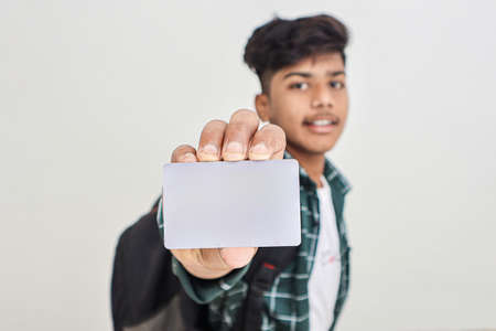 Young indian man showing debit or credit card on white background.の写真素材