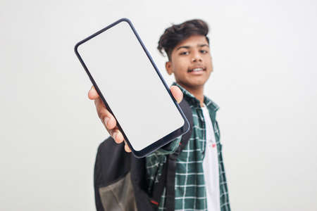 Young indian college student showing smartphone Screen on white background.の写真素材