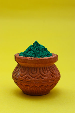 Indian festival Holi concept green colour bowl on yellow background.の写真素材
