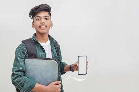 Young indian college student showing smartphone Screen on white background.の写真素材