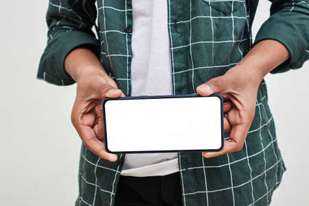 Young indian college student showing smartphone Screen on white background.
