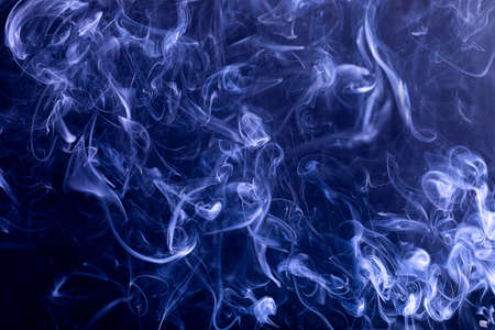 Smoke spread throughout the image with a neutral dark blue backgroundの写真素材