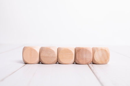 Wooden cubes in a row on a light backgroundの写真素材