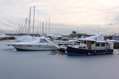 Frozen marina in winter with covered boats on ice - Toronto, Ontario, Canadaの写真素材