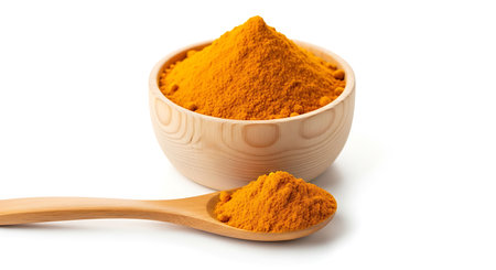 A close-up of bright yellow turmeric powder, piled high in a wooden bowl and spoon.の素材