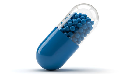 A single, translucent capsule with a blue half filled with numerous tiny blue pellets is shown.の素材