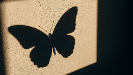 Ethereal butterfly shadow on a warm beige wall, evoking feelings of serenity and hope.の素材