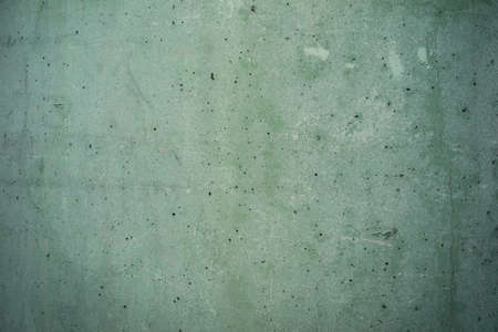 damaged green concrete background texture with small holes and scratches