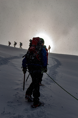 Mountaineer in sunrise on a snowy ascent on a alpine tour called Spaghetti Round in the European Alps, Monte Rosa Massif, Italyの写真素材